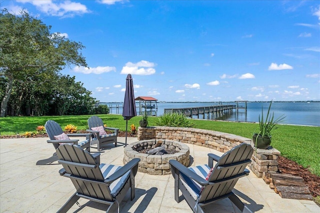 view of patio / terrace featuring a boat dock, a water view, and an outdoor fire pit