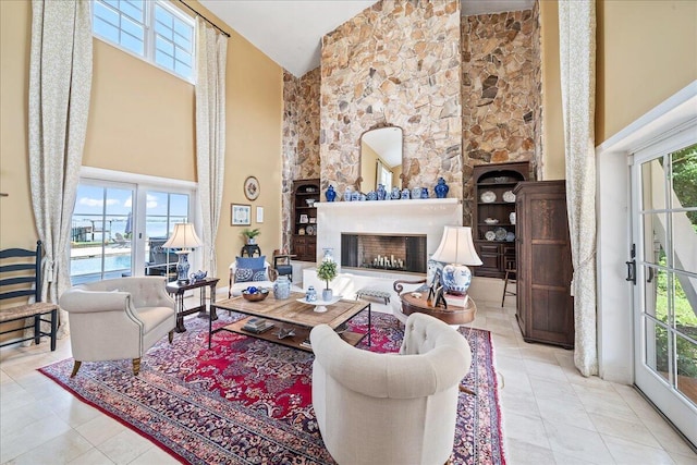 tiled living room featuring a healthy amount of sunlight, a fireplace, and high vaulted ceiling