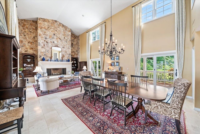 tiled dining area featuring a fireplace, high vaulted ceiling, and a chandelier