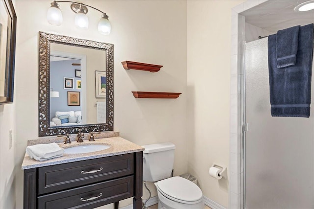 bathroom featuring vanity, toilet, and walk in shower