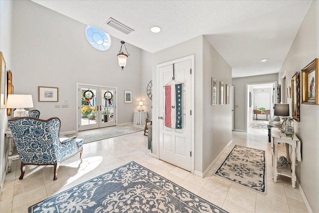 tiled foyer entrance featuring french doors and a textured ceiling