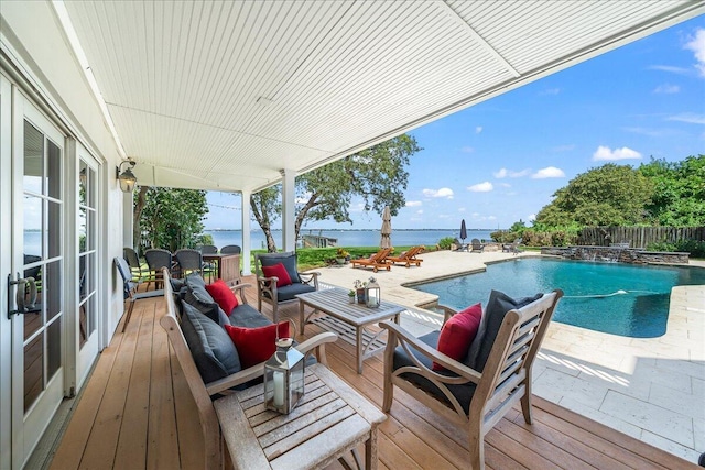 wooden deck featuring outdoor lounge area, pool water feature, a water view, and a patio