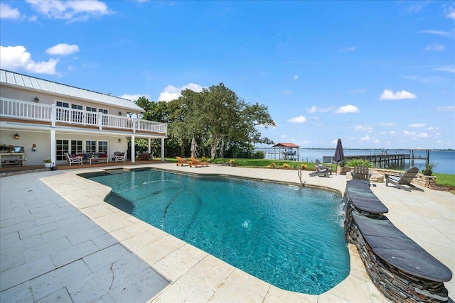 view of swimming pool featuring pool water feature, a water view, and a patio