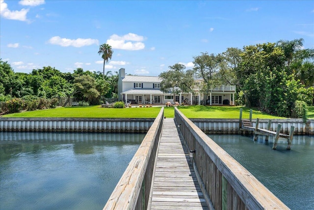 dock area featuring a yard and a water view