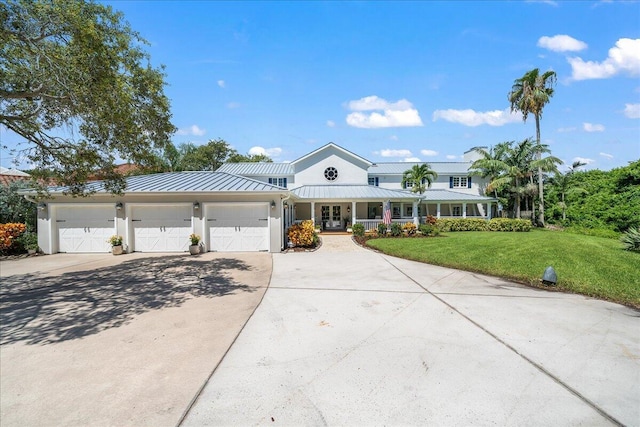 view of front of house featuring a porch, a garage, and a front lawn