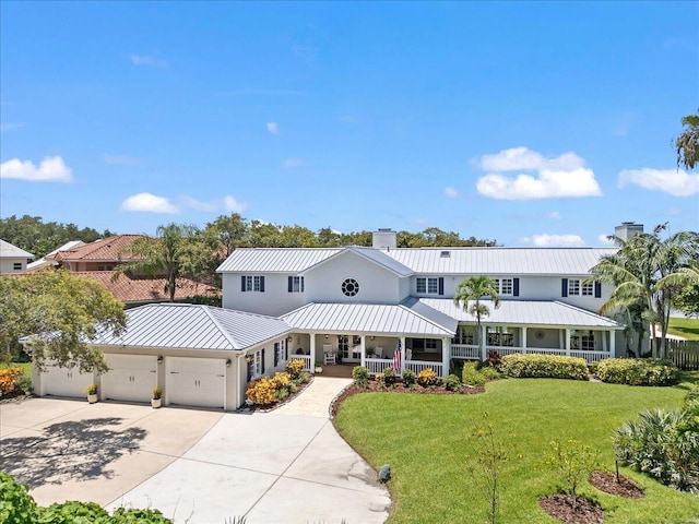 view of front of property featuring a porch, a front yard, and a garage