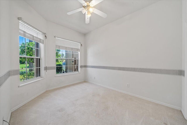 carpeted spare room with ceiling fan