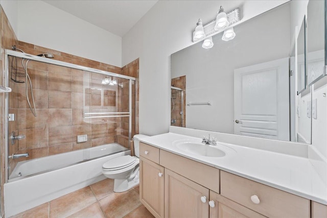 full bathroom with combined bath / shower with glass door, vanity, toilet, and tile patterned flooring