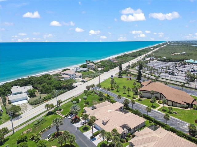 birds eye view of property with a water view and a beach view