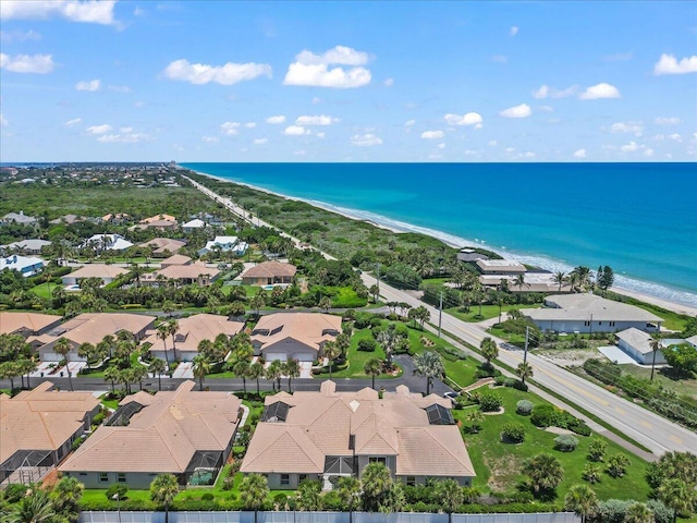 drone / aerial view with a water view and a beach view