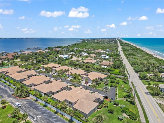 drone / aerial view featuring a water view and a beach view