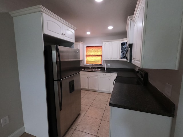 kitchen featuring white cabinets, appliances with stainless steel finishes, sink, and light tile flooring