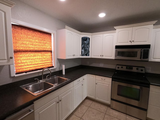 kitchen with sink, white cabinets, light tile floors, and appliances with stainless steel finishes