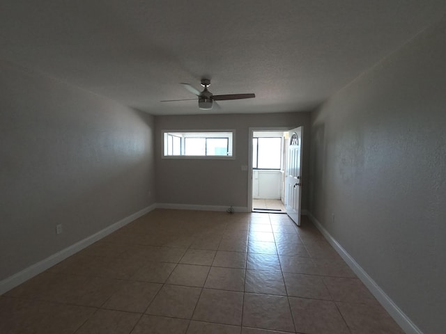 spare room featuring tile floors and ceiling fan