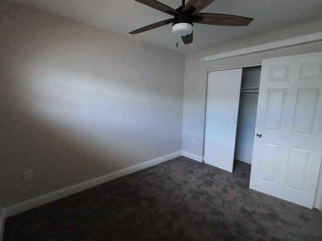 unfurnished bedroom featuring ceiling fan, a closet, and dark carpet