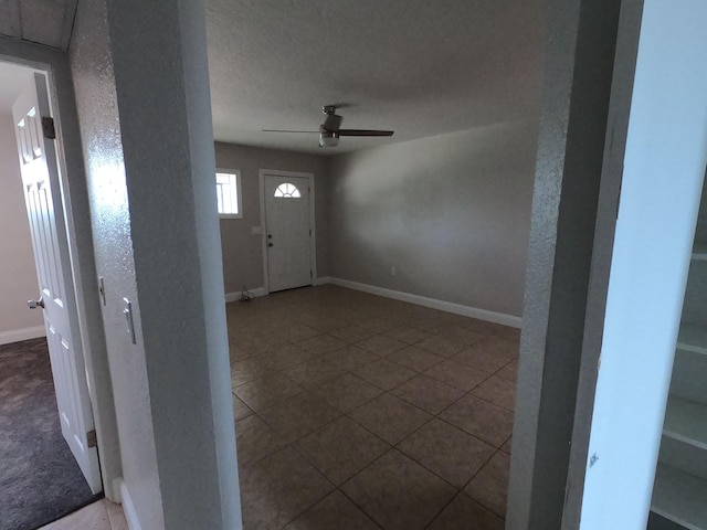 entryway with ceiling fan, a textured ceiling, and carpet floors