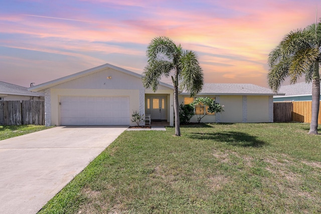 single story home with a yard and a garage