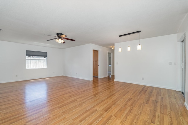 unfurnished room featuring a textured ceiling, ceiling fan, and light hardwood / wood-style flooring