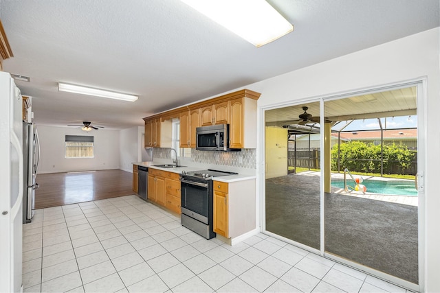 kitchen featuring stainless steel appliances, decorative backsplash, a healthy amount of sunlight, and sink