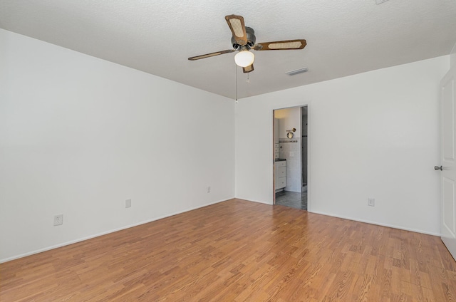 spare room with light hardwood / wood-style floors, ceiling fan, and a textured ceiling