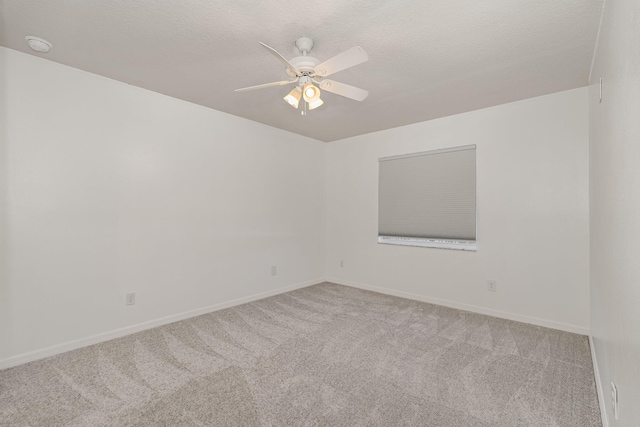 carpeted spare room featuring ceiling fan and a textured ceiling