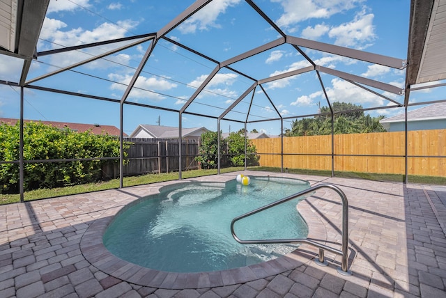 view of swimming pool with glass enclosure and a patio area