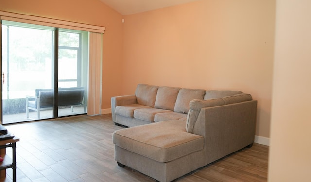 living room with vaulted ceiling and light hardwood / wood-style flooring