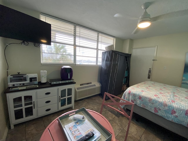 bedroom with a wall unit AC and ceiling fan