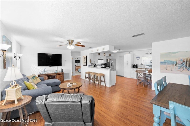 202 Monroe Ave, Cape Canaveral, FL 32920 - living room featuring ceiling fan, light hardwood / wood-style flooring, and a textured ceiling
