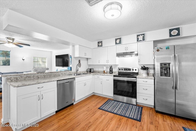 kitchen featuring appliances with stainless steel finishes, sink, white cabinets, light hardwood / wood-style floors, and a textured ceiling