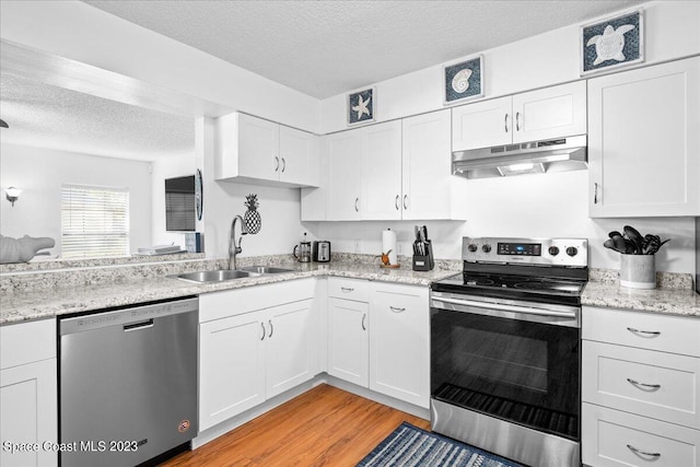202 Monroe Ave, Cape Canaveral, FL 32920 - kitchen with white cabinetry, sink, light hardwood / wood-style floors, stainless steel appliances, and a textured ceiling