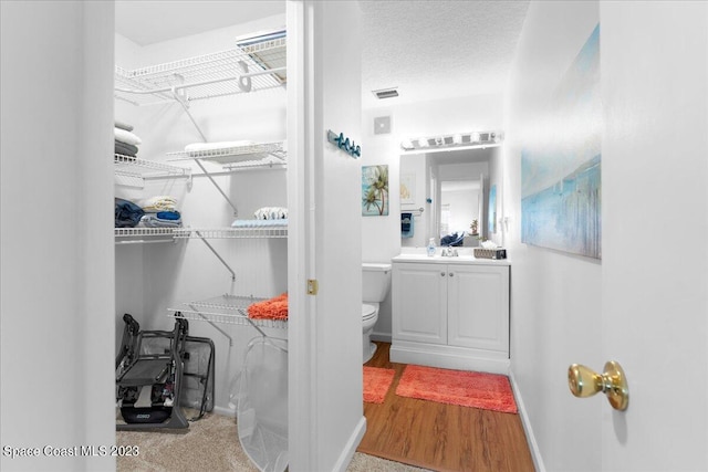202 Monroe Ave, Cape Canaveral, FL 32920 - bathroom with hardwood / wood-style flooring, vanity, toilet, and a textured ceiling