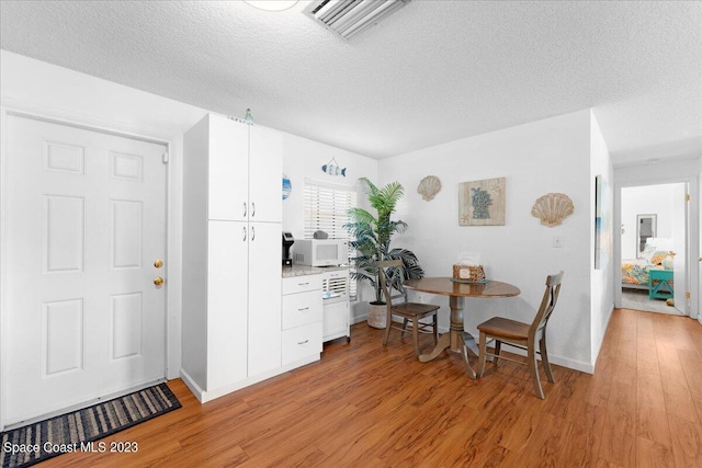 202 Monroe Ave, Cape Canaveral, FL 32920 - living area featuring a textured ceiling and light hardwood / wood-style floors