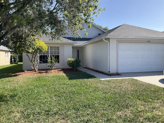 ranch-style house featuring a front yard and a garage