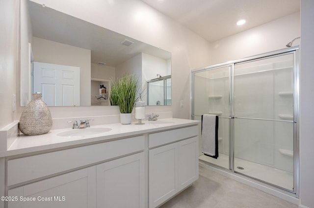 bathroom featuring a shower with door and vanity