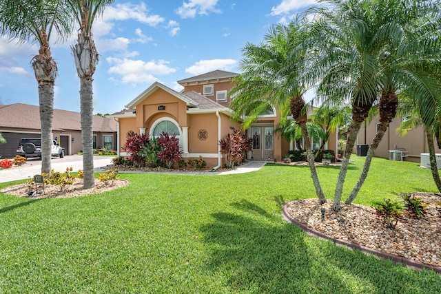 mediterranean / spanish home with cooling unit, a front yard, and french doors