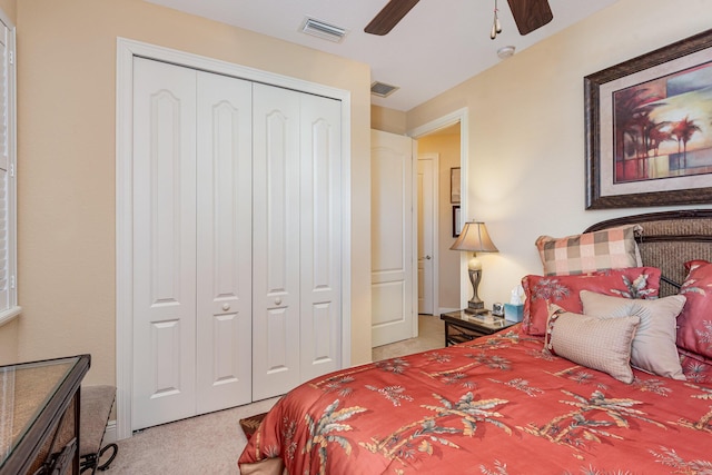 bedroom with ceiling fan, a closet, and light carpet