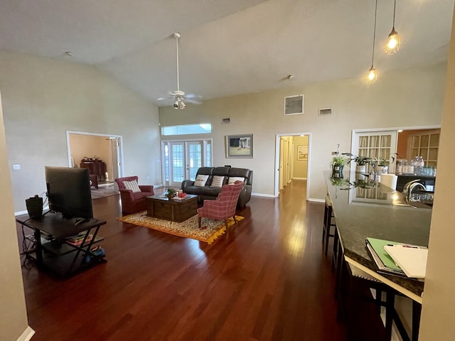 living room with dark hardwood / wood-style flooring, ceiling fan, french doors, and high vaulted ceiling