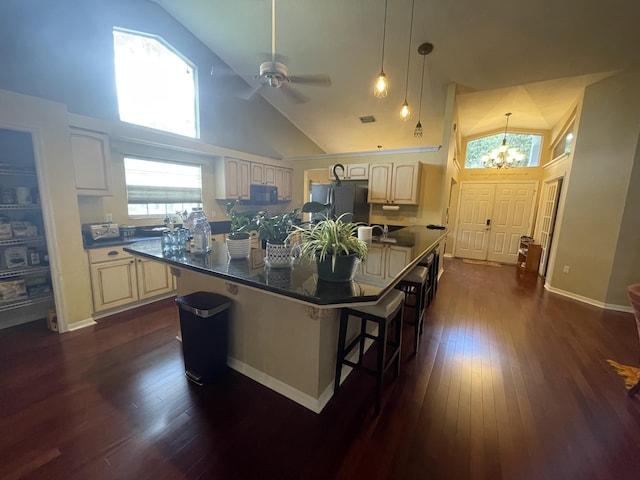 kitchen with a kitchen breakfast bar, a center island, high vaulted ceiling, and black appliances