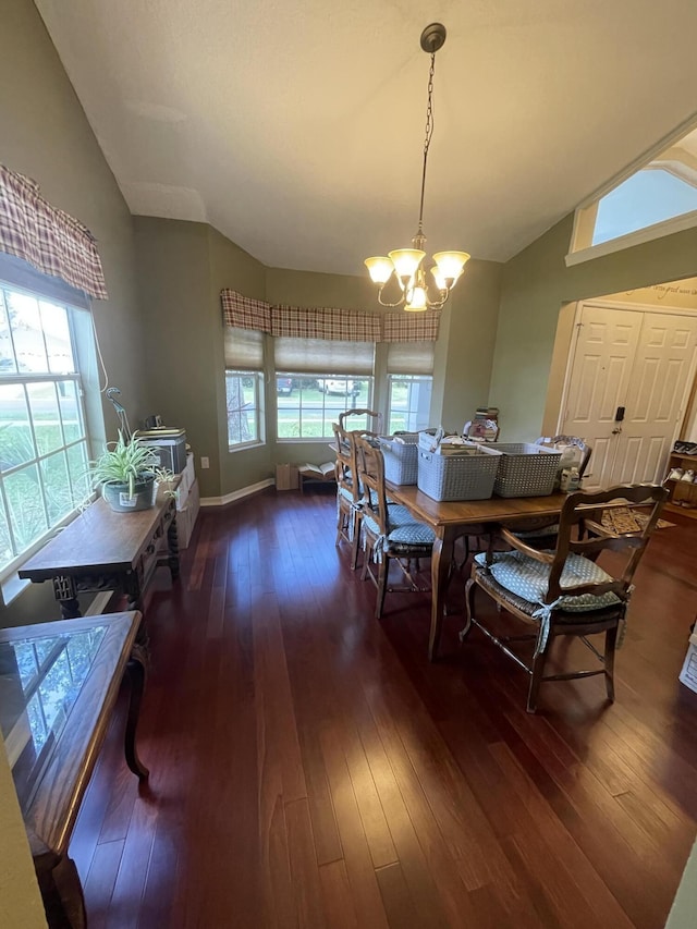 dining area featuring vaulted ceiling, dark hardwood / wood-style floors, and an inviting chandelier