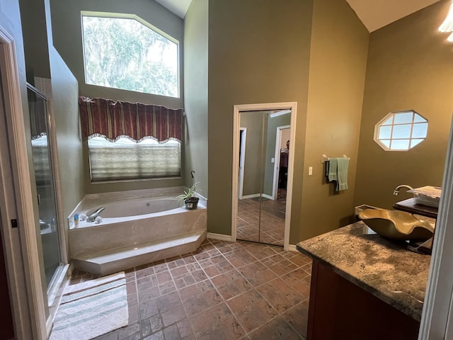 bathroom with a towering ceiling, vanity, and separate shower and tub