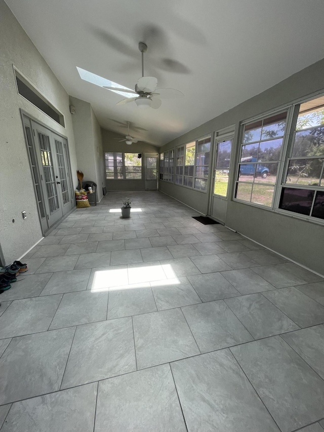 unfurnished sunroom featuring french doors, lofted ceiling with skylight, and ceiling fan