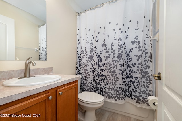 full bathroom featuring toilet, vanity, hardwood / wood-style floors, and shower / bath combination with curtain