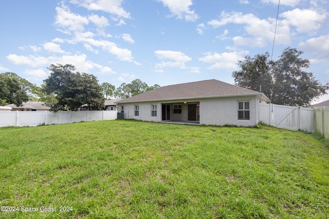 rear view of property featuring a lawn