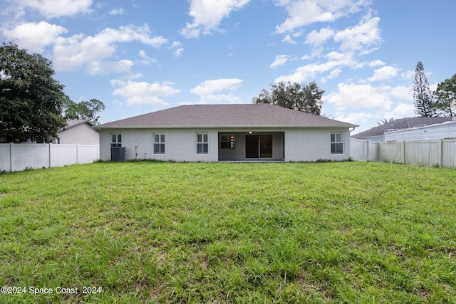 rear view of property featuring a yard