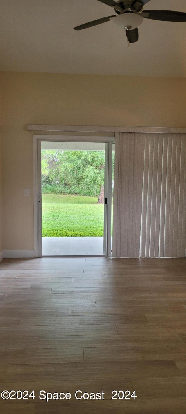 empty room featuring ceiling fan, plenty of natural light, and hardwood / wood-style floors