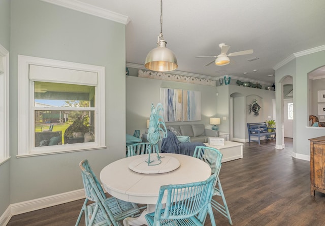 dining area featuring crown molding, dark wood-type flooring, and ceiling fan