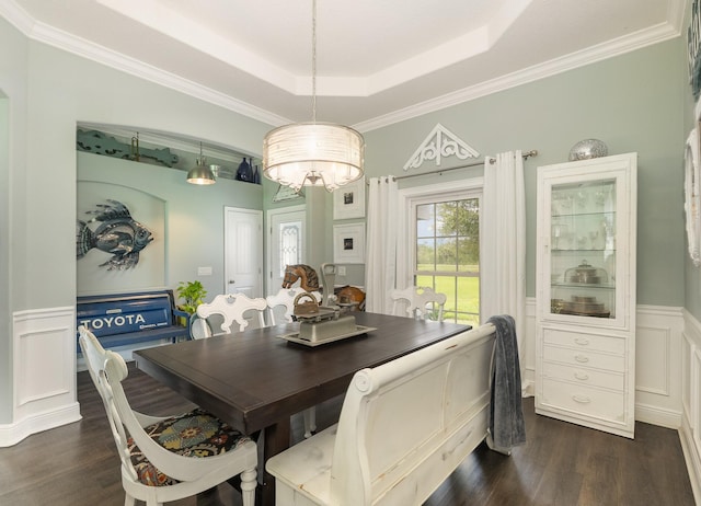 dining area featuring a raised ceiling, dark hardwood / wood-style flooring, and crown molding