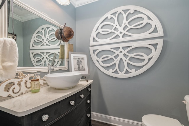 bathroom featuring crown molding, vanity, and toilet