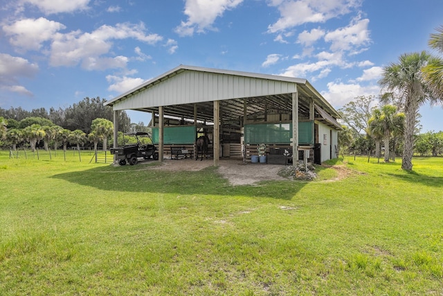 rear view of property with an outdoor structure and a yard